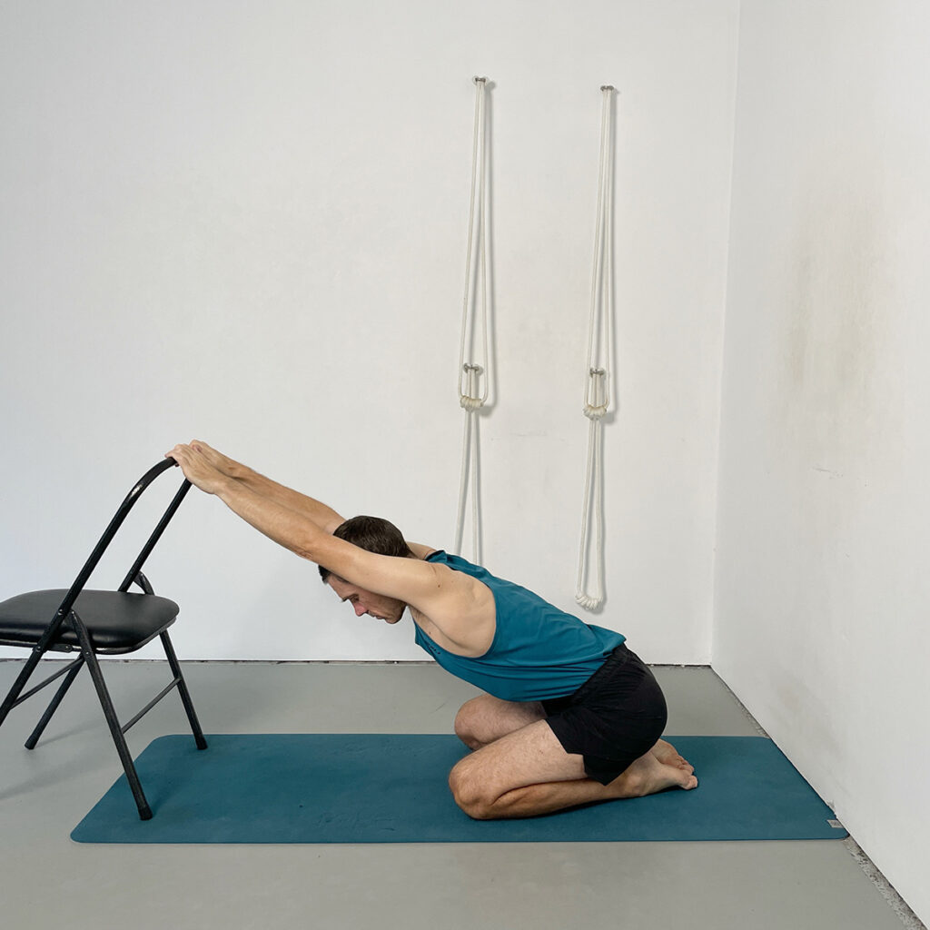 Adho Mukha Virasana (Downward Facing Hero Pose) Variation with Chair Support