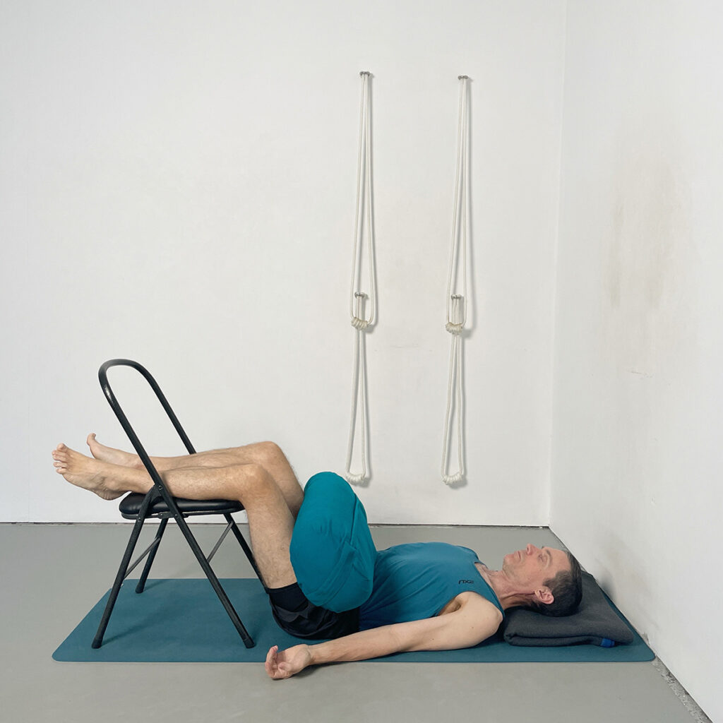 Supported Savasana (Calves on Chair with Bolster on Pelvis)